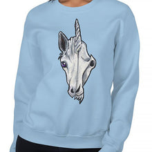 Load image into Gallery viewer, A woman is wearing a unisex sweatshirt in the colour light blue, which is printed with a split graphic: the left side features the face of a unicorn, and the right side features an evil looking skull
