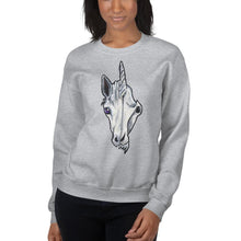 Load image into Gallery viewer, A woman is wearing a unisex sweatshirt in the colour sport grey, which is printed with a split graphic: the left side features the face of a unicorn, and the right side features an evil looking skull
