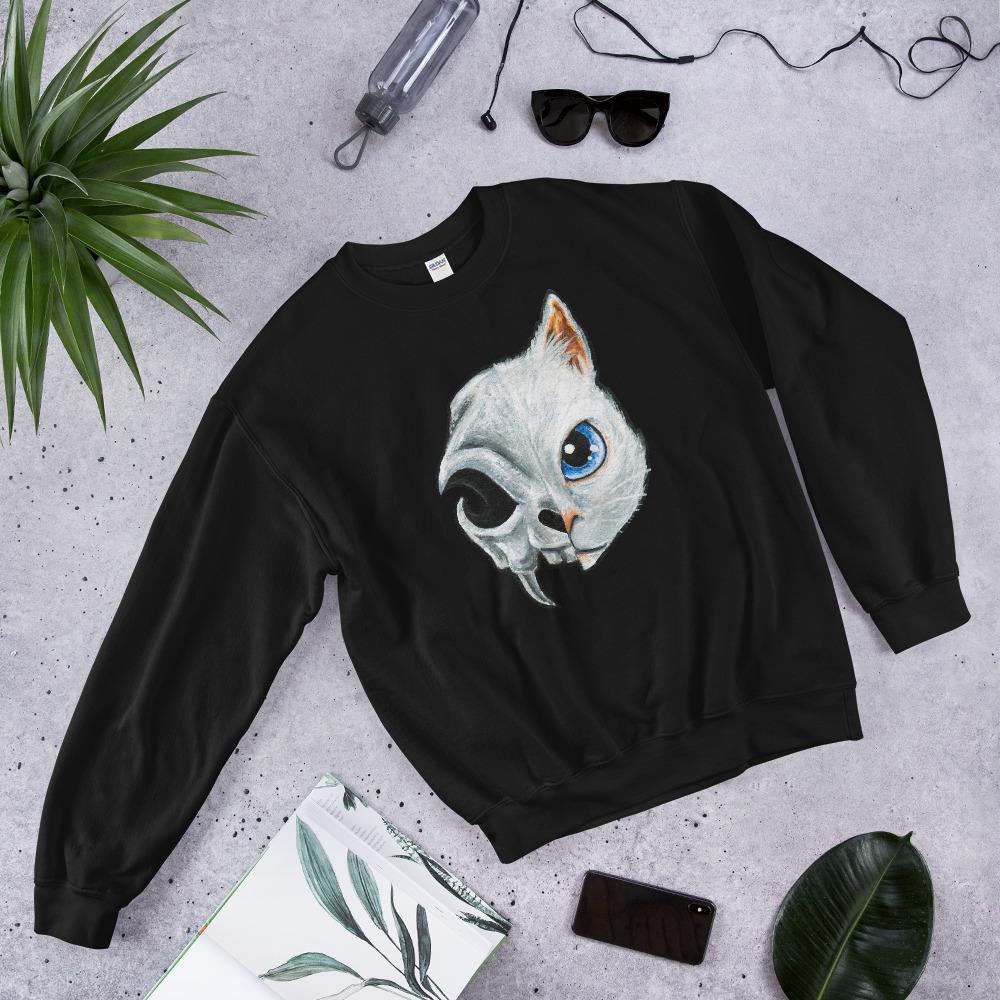 A unisex sweatshirt in the colour black, printed with art split into two: the right side features the face of a blue eyed white cat, and the left side features an evil looking cat skull.