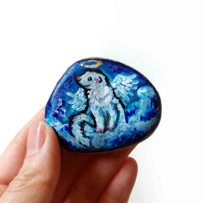 rock art of a white ferret, painted as an angel, sitting on fluffy clouds against a blue sky