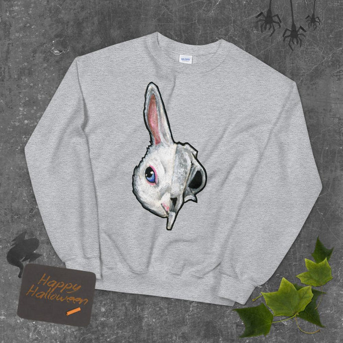 A unisex sweatshirt in the colour sport grey, printed with art of a split image: the left side features a white rabbit's face, and the right side features a scary looking rabbit skull