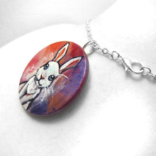 Load image into Gallery viewer, A circle wood disc painted with art of a white rabbit with blue eyes, available as a keepsake or necklace
