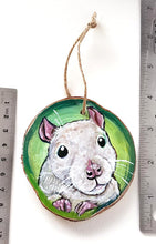 Load image into Gallery viewer, A Christmas wood ornament, hand painted with art of a white fancy rat, in front of a green background
