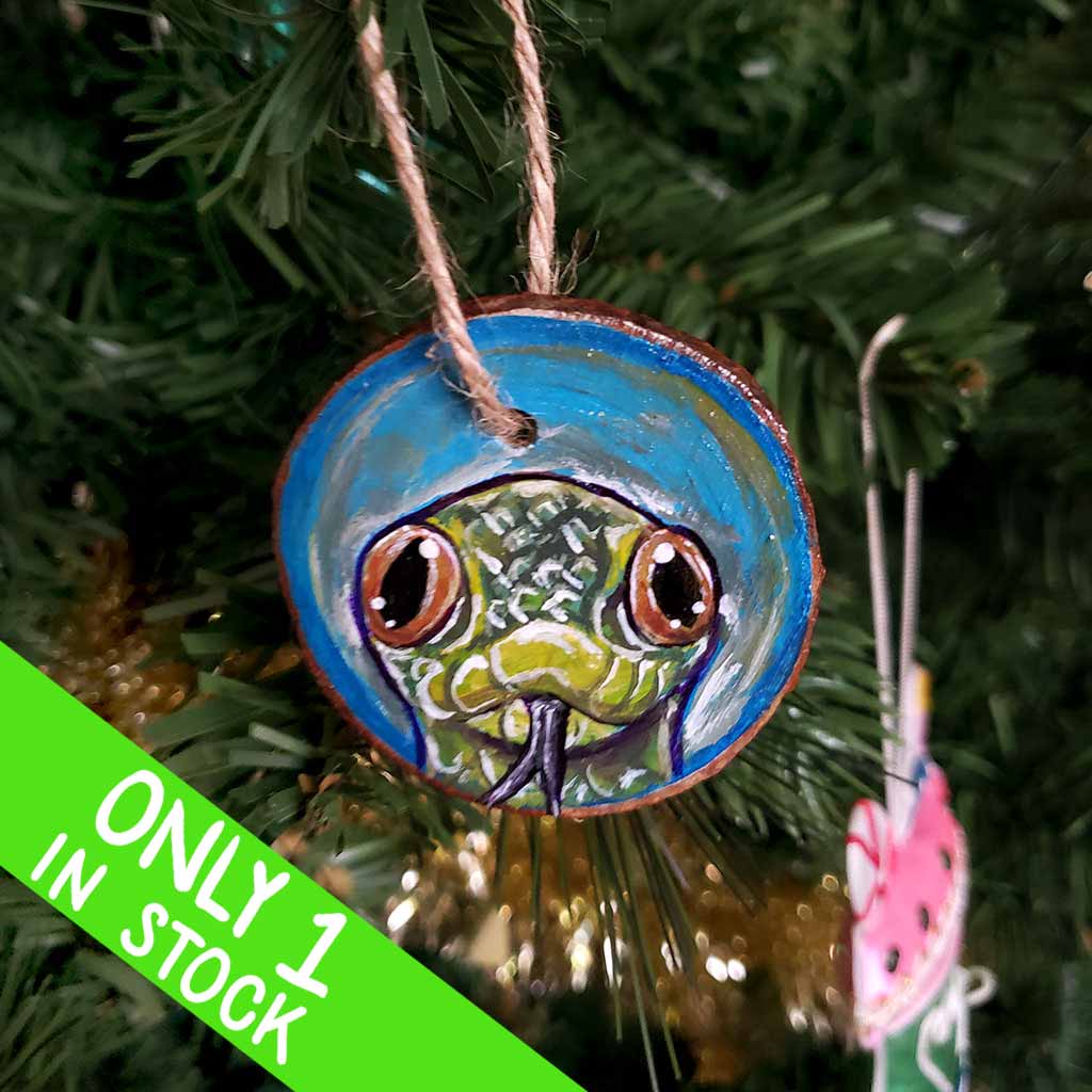 A tree ornament, hand painted with art of a yellow anaconda snake
