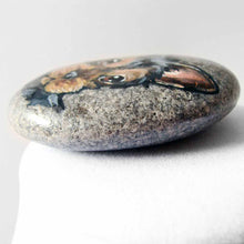Load image into Gallery viewer, a beach stone, hand painted with the portrait of a black and brown yorkie&#39;s face
